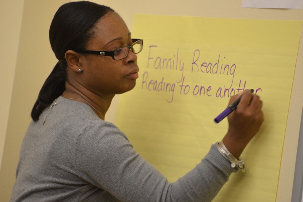 Ed.D. student Tayarisha Stone is writing down strategies on a large yellow post-it, during her time in the Ed.D. Program