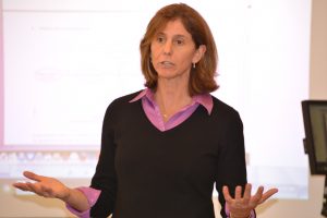 Dr. Laura Burton in the front of a classroom during SPM meeting